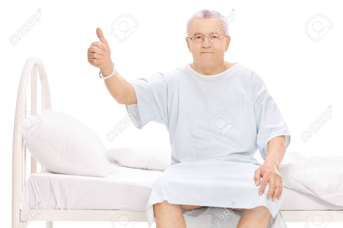 39020230-mature-patient-sitting-on-a-hospital-bed-giving-a-thumb-up-and-looking-at-the-camera-isolated-on-whi.jpg