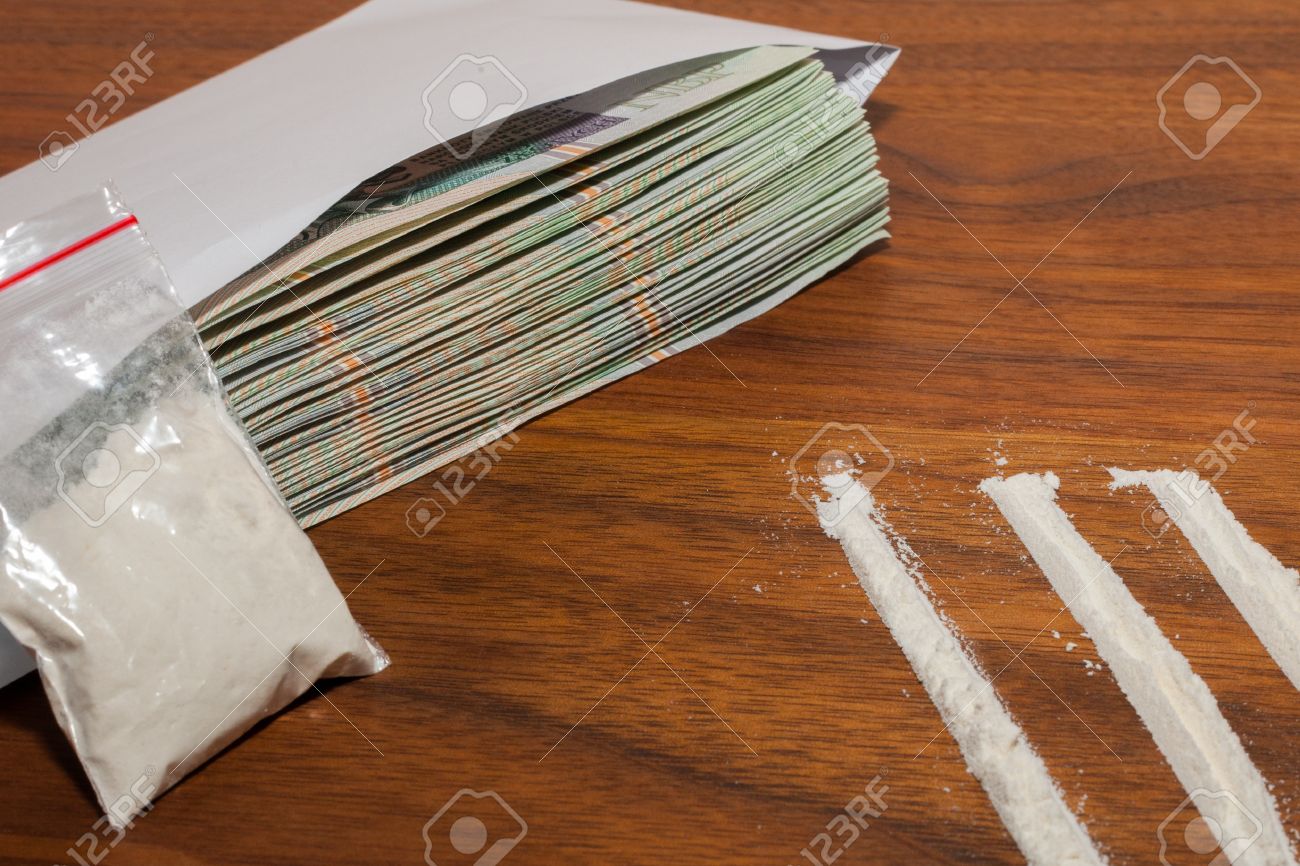 15654627-A-lot-of-money-in-the-envelope-and-drugs-narcotic-cocaine-on-a-wooden-table-Polish-zloty--Stock-Photo.jpg