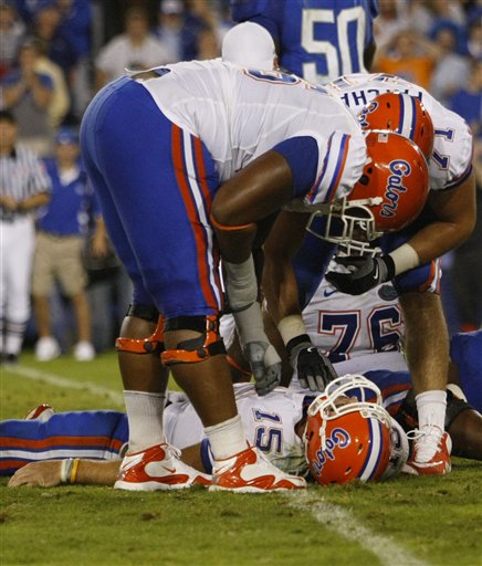 teammates-james-wilson-and-matt-patchan-look-over-quarterback-tim-tebow-as-he-lays-on-the-ground-having-been-sacked.jpg