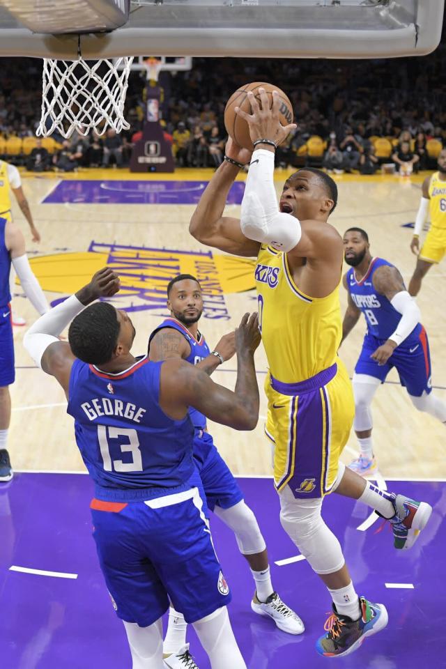 Lakers guard Russell Westbrook elevates for a layup over Clippers forward Paul George.